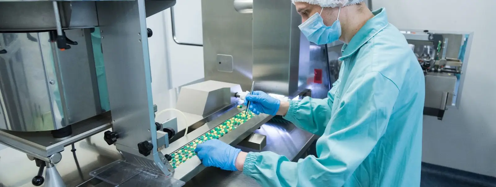 Seorang pria mengawasi produksi tablet farmasi
